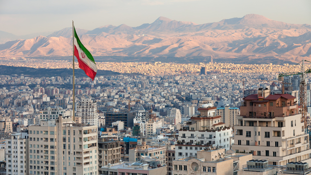 Waving,Iran,Flag,Above,Skyline,Of,Tehran,At,Sunset.